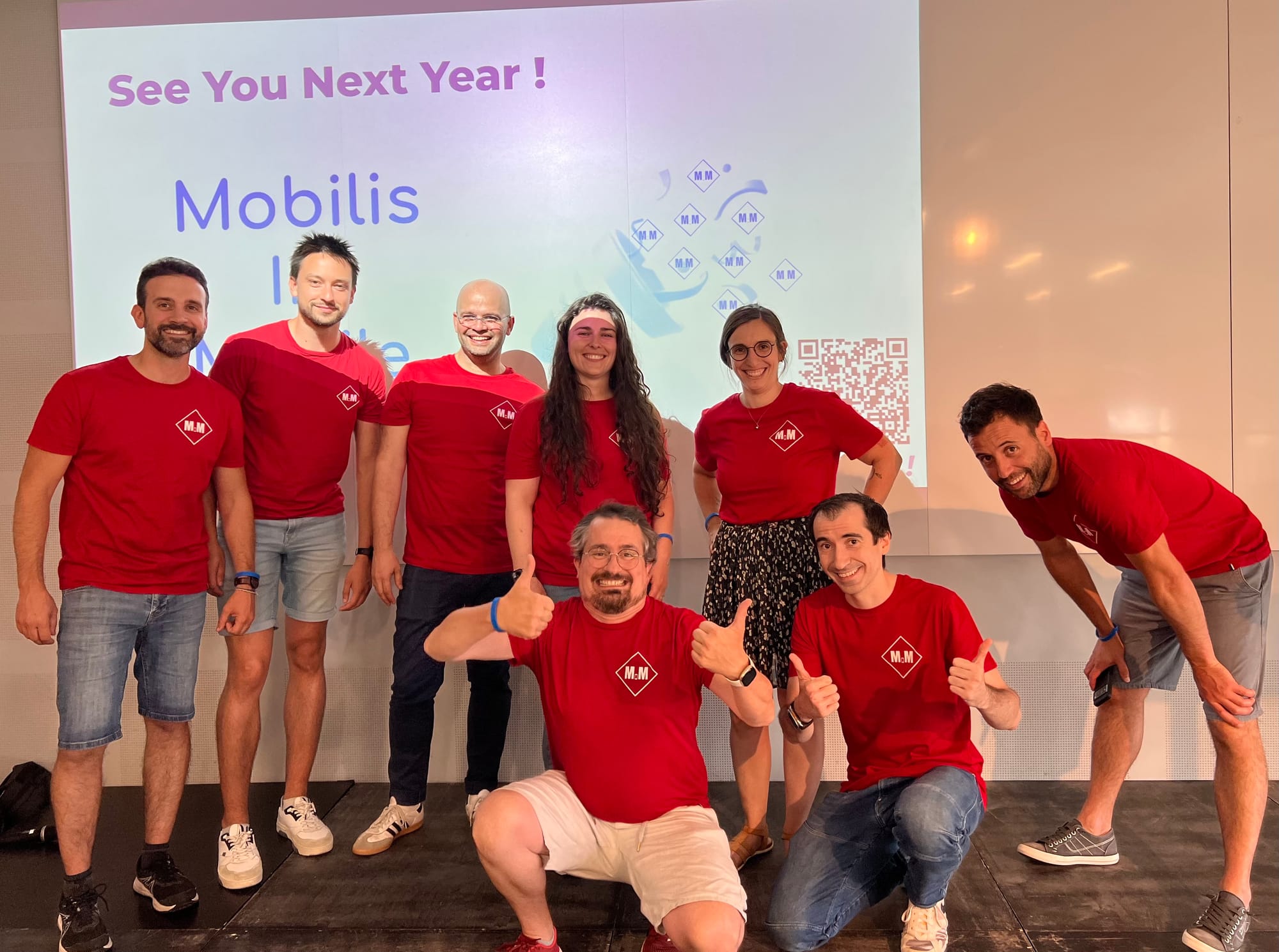 Photo de l'équipe d'organisation au complet. On y voit 6 hommes et 2 femmes, tous habillés d'un tshirt rouge où est écrit M M.