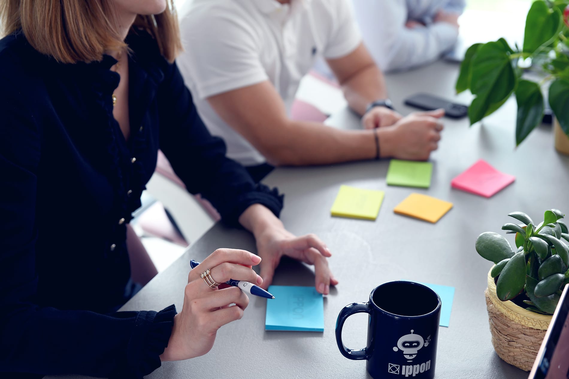 Photo de salariés en train d'écrire sur des post-it.