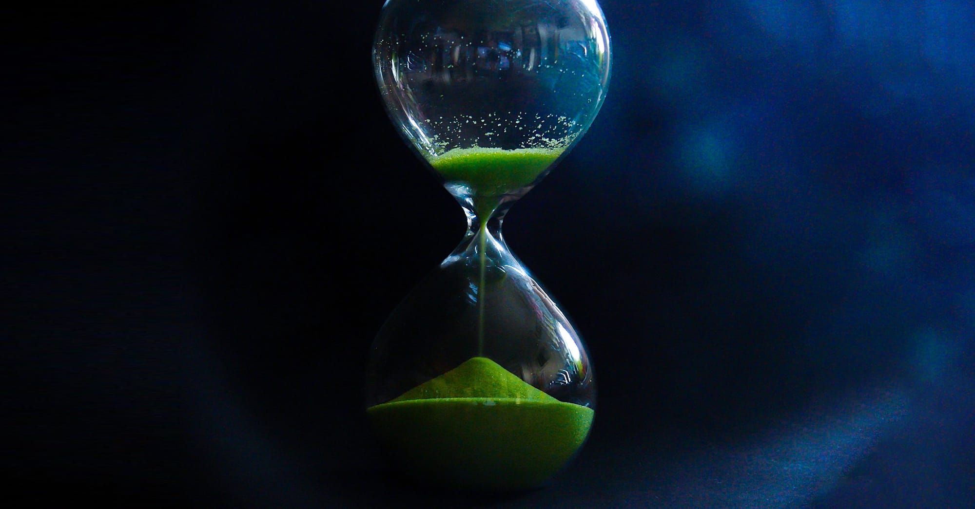 Photo d'illustration d'un sablier dont le sable est vert.